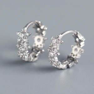 Macro shot of silver star-shaped hoop earrings with sparkling cubic zirconia inlay