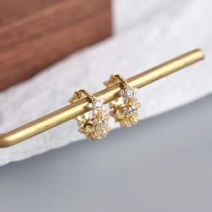 Macro detail of gold sterling silver star earrings with sparkling cubic zirconia crystals
