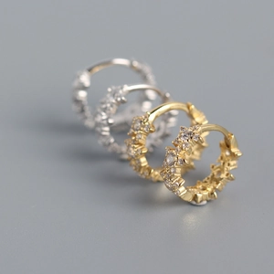 Macro shot of silver and gold S925 sterling silver star hoop earrings with clear zircons