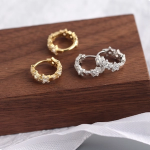 Macro shot of silver and gold S925 sterling silver star earrings with pavé crystals