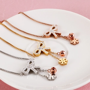 Titanium steel butterfly charm bracelets in rose gold, gold, and silver on a ceramic plate