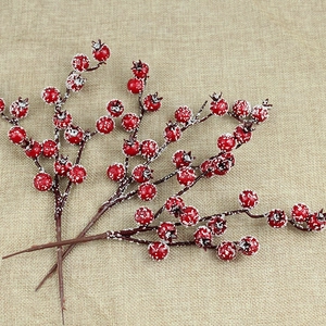 Macro detail of red Christmas foam berries with white faux snow on beige linen cloth