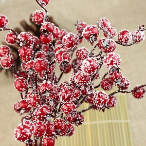 Close-up of frosted artificial red berries with snowy texture for Christmas tree decor