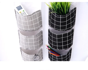 Detailed view of 3-pocket cotton linen wall organizers in black and grey plaid patterns