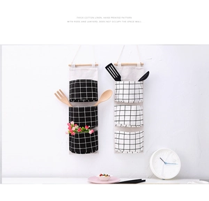 Detailed view of two checkered cotton linen hanging wall organizers with 3 large pockets