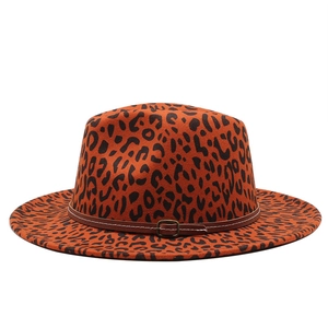 Detail of leopard print fedora hat featuring orange base and brown faux leather band