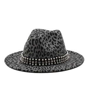 Détail de chapeau fedora léopard avec ruban en velours, strass et perles blanches