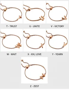 Détail de bracelets en or rose avec lettres T à Z et pendentifs à texture de bambou