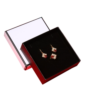 Elegant gold jewelry set with red gems and diamonds in a premium black gift box