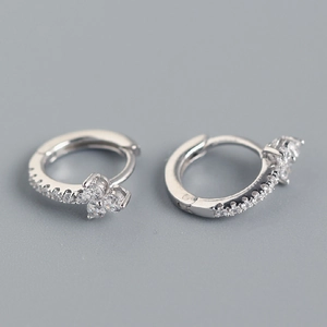 Macro shot of silver floral hoop earrings with sparkling butterfly zircon embellishments