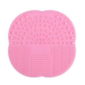 Pink silicone makeup brush cleaning mat with suction cups and multi-texture surface