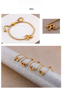 Close-up of gold bamboo-style letter pendants and adjustable slider with heart ends