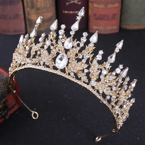 Close-up of golden baroque bridal crown with crystals and rhinestones on vintage books