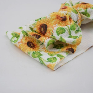 Macro shot of fabric headband showing crinkle seersucker texture and sunflower print
