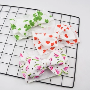 Detailed view of three baby headbands with clover, heart, and watermelon bow patterns
