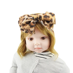 Detailed macro shot of a brown leopard print fabric bow headband on a baby model head