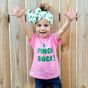 Detailed view of pink cotton kids t-shirt with I PINCH BACK text on a young girl