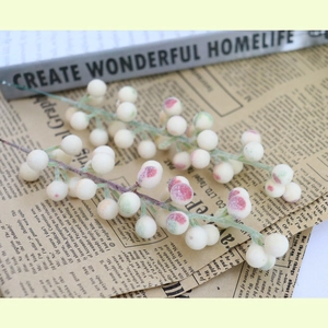 Fuzzy white artificial berry stems for Christmas DIY crafts on vintage book background