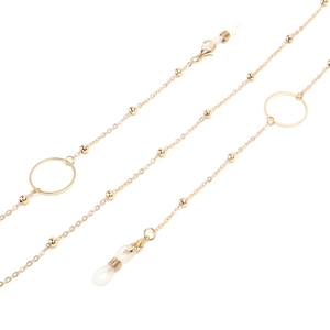 Detailed shot of golden eyewear chain featuring metal beads, rings, and silicone connectors