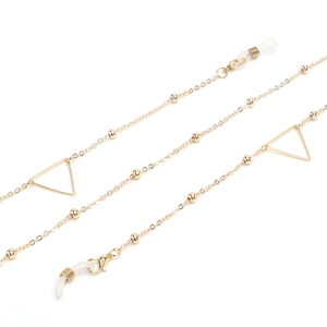 Detailed view of golden glasses chain featuring triangle charms and white silicone loops