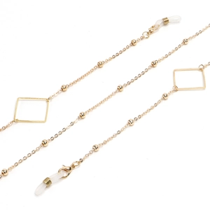 Detail of golden glasses chain featuring small beads and square geometric frames