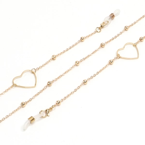 Detail of golden glasses chain featuring hollow heart charms and lobster clasps