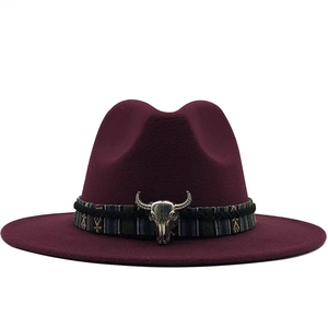Détail d'un chapeau fedora bordeaux avec ruban ethnique et ornement de tête de taureau
