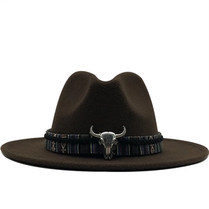 Détail d'un chapeau de cowboy marron avec bande ethnique et ornement crâne de taureau argent