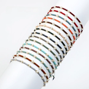 Detail of colorful Bohemian Miyuki seed bead bracelets with freshwater pearls and gold beads