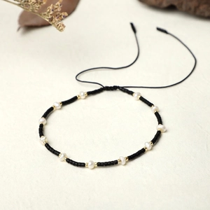 Detail of handmade MIYUKI seed bead bracelet with freshwater pearls and adjustable black cord