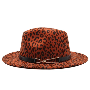 Dettaglio di un cappello fedora leopardato con fascia in pelle e fibbia in metallo oro