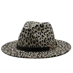 Dettaglio cappello fedora leopardato con fibbia dorata e cinturino in pelle nera chic