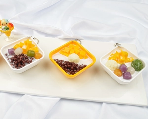 Macro view of simulation dessert keychain with mango cubes and red beans