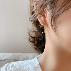 Elegant gold butterfly earrings with sparkling crystals worn by a model in a close-up shot