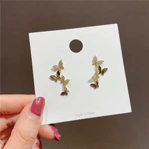 Macro view of gold-plated butterfly earrings with sparkling cubic zirconia on card