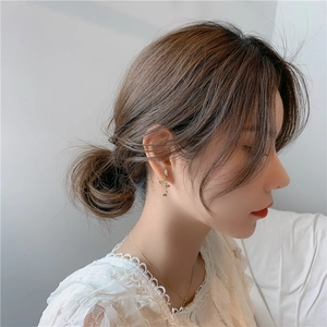 Close-up of elegant gold butterfly and leaf drop earrings worn by a model