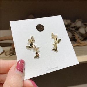 Close-up of golden butterfly earrings with sparkling cubic zirconia on a card