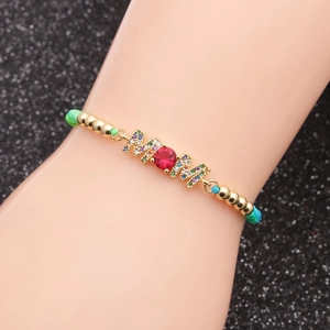 Detail of MOM letter charm bracelet with micro-pawned zircons on woven green cord