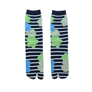 Close-up of Tabi socks with green floral patterns and blue horizontal stripes