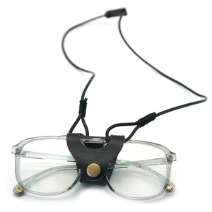 Detail view of black faux leather strap connector with metal snap on clear frame glasses