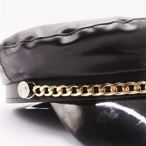 Black PU leather baker boy hat featuring a shiny visor and decorative gold metal chain