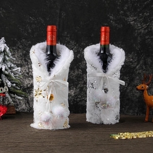 White plush Christmas wine bottle covers with gold and silver snowflakes and pom-pom ribbons
