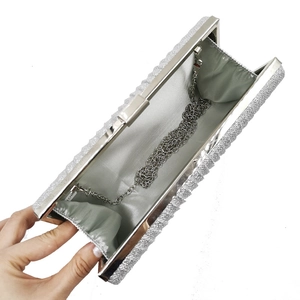 Detail of silver sequin evening clutch bag showing grey silk lining and detachable chain