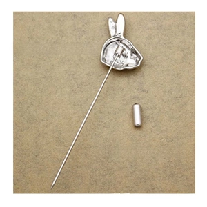 Macro detail of silver rabbit pin with polished copper needle and safety cap