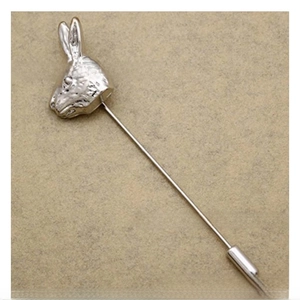 Detailed view of silver rabbit lapel pin with long copper needle on beige background