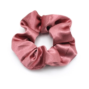 Close-up of pink satin scrunchie showing smooth texture and soft silk-like shine