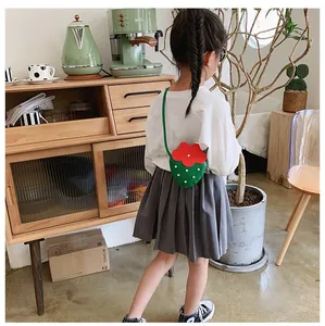Toddler girl wearing strawberry-shaped crossbody bag with red and green color detail