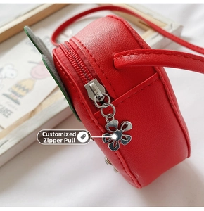 Close-up of the strawberry bag featuring a silver hollow flower-shaped zipper puller