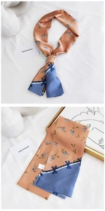 Close-up of narrow silk twilly scarf with coral floral print and navy blue color block