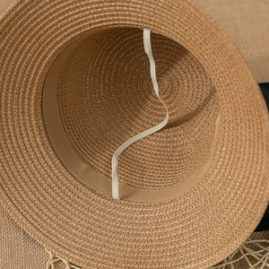 Detail view of woven straw hat interior featuring the sweatband and elastic wind rope